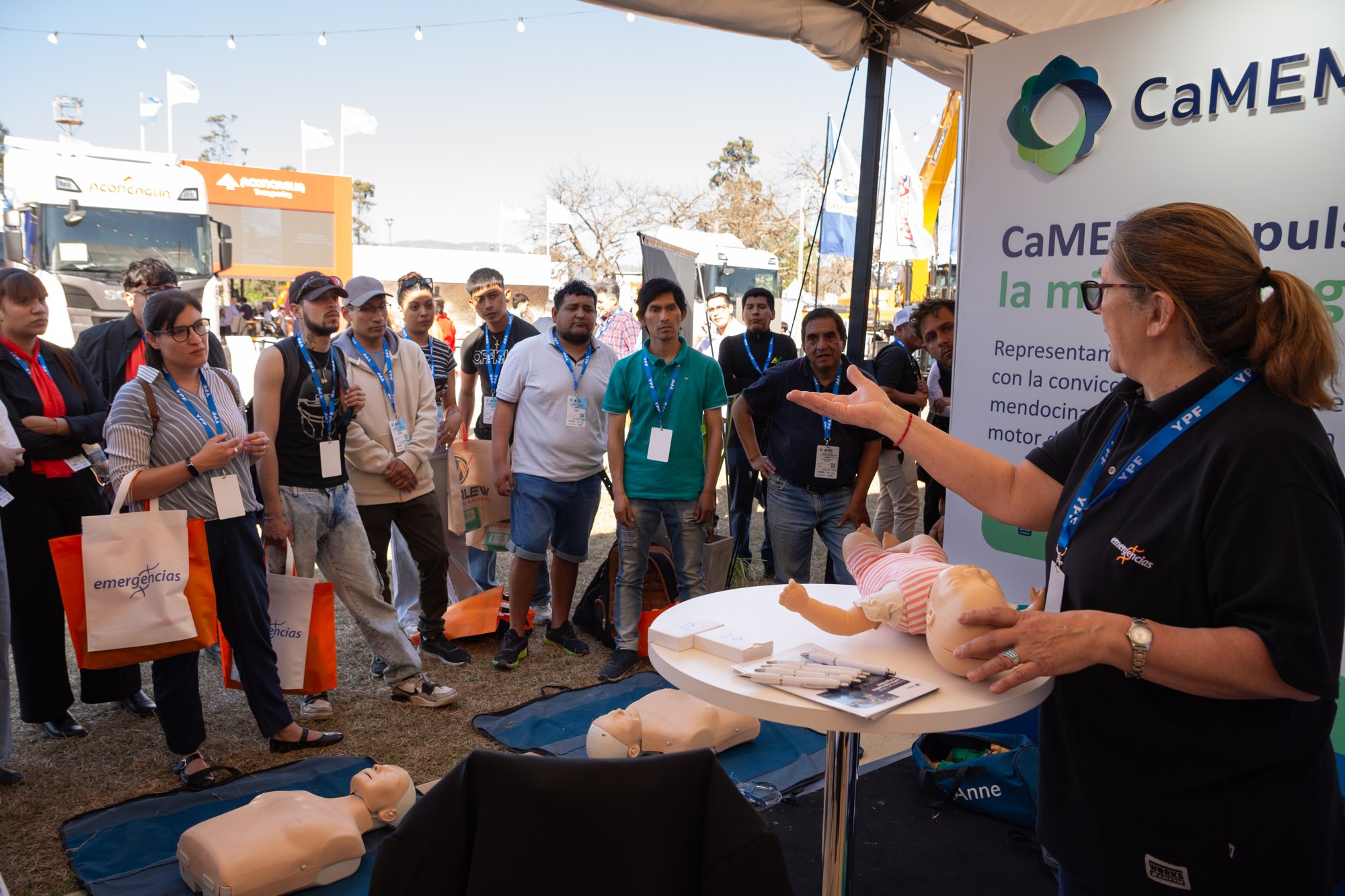 Integrante de Emergencias explica una demostración con maniquíes de entrenamiento ante un grupo de asistentes en Argentina Mining Norte 2026
