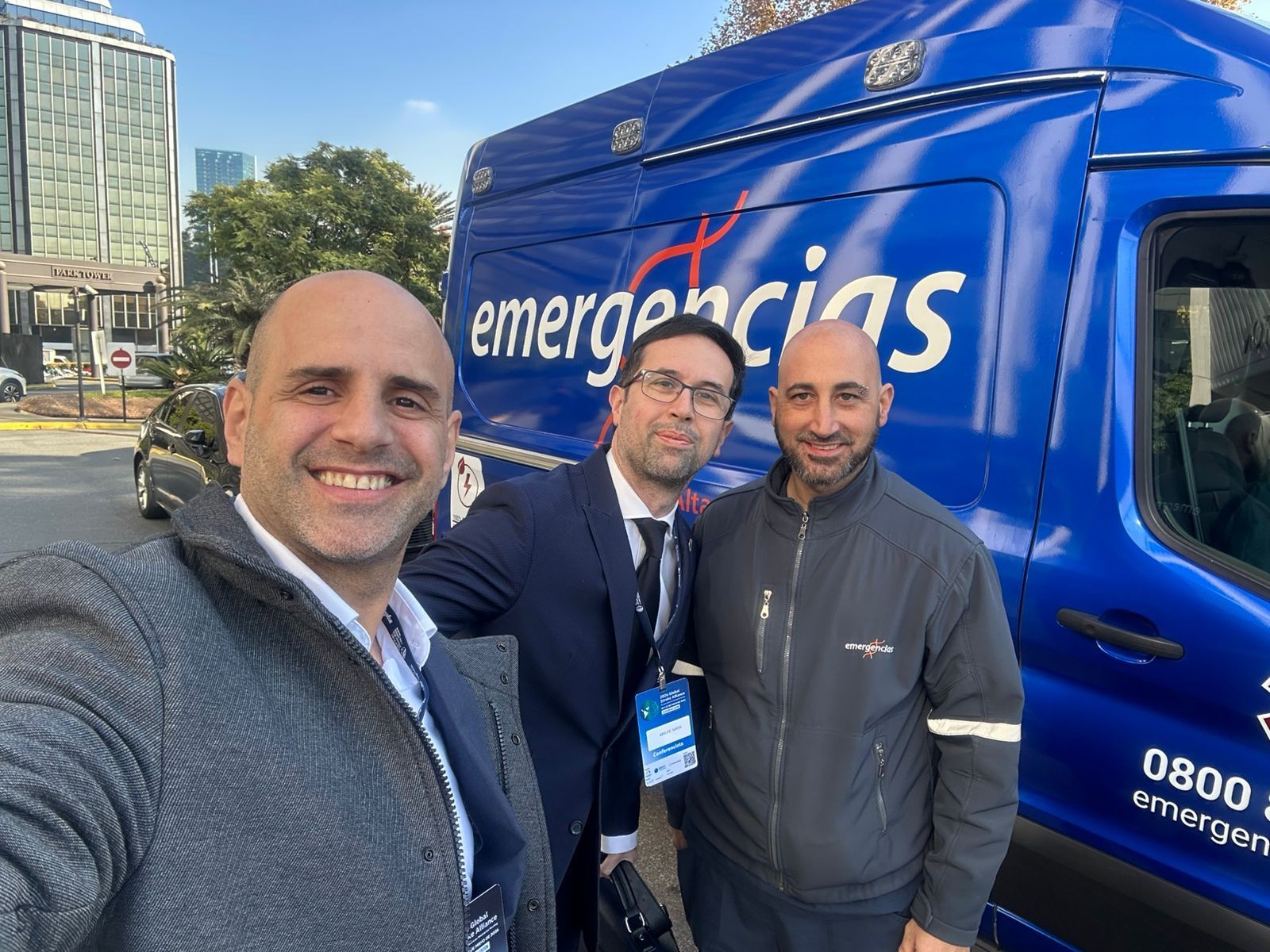 Tres integrantes del equipo de Emergencias junto a una unidad sanitaria azul de Emergencias durante el Global Stroke Alliance 2026