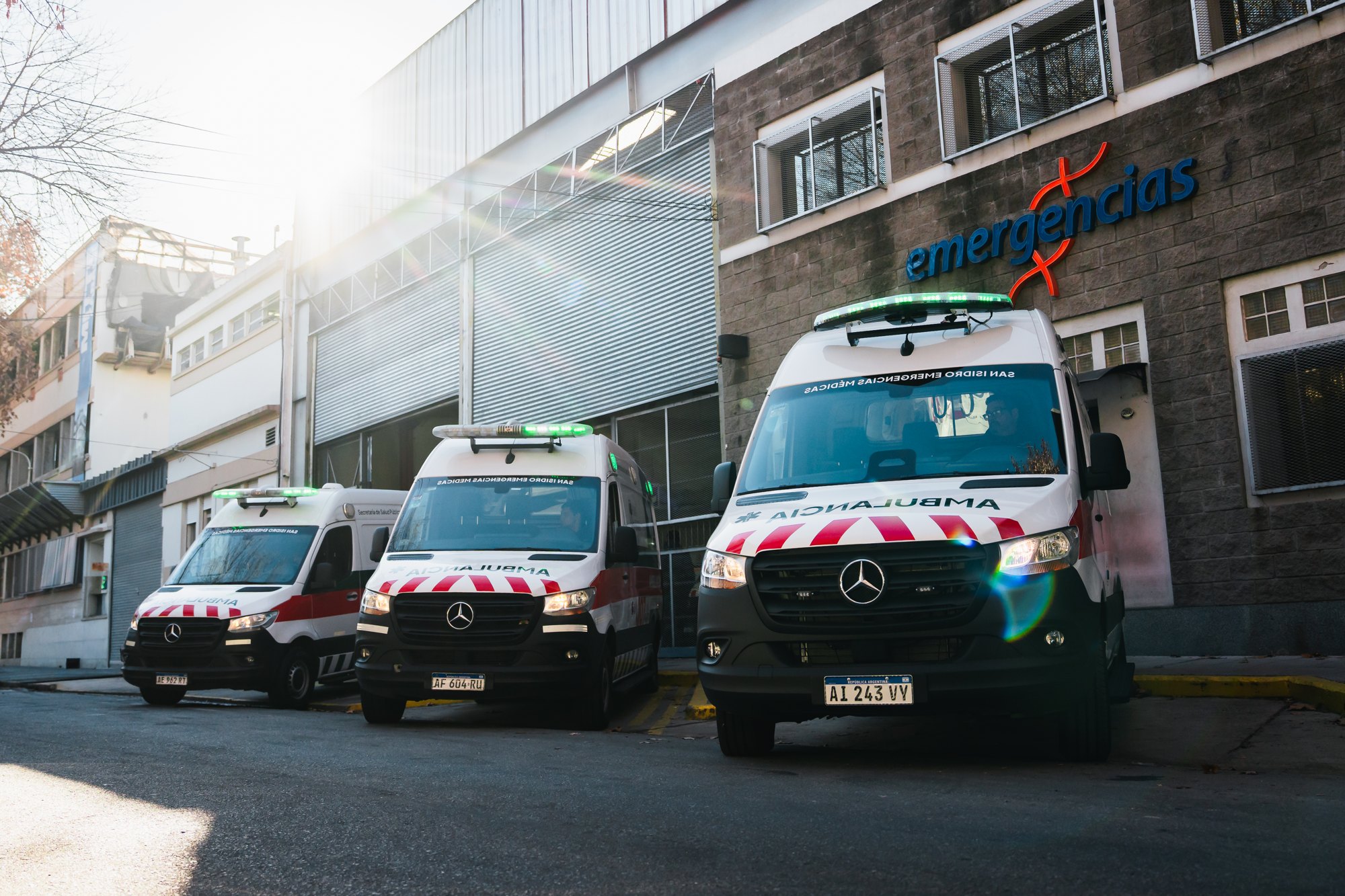 Tres ambulancias del servicio San Isidro Emergencias Médicas estacionadas frente a la sede de Emergencias
